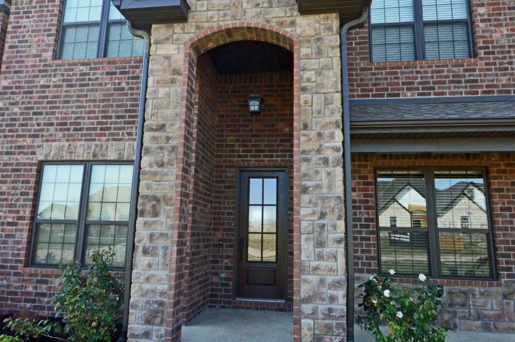 A close up shot of a large elegant arched window now perfectly clear in an upscale home reminiscent of-River Oaks